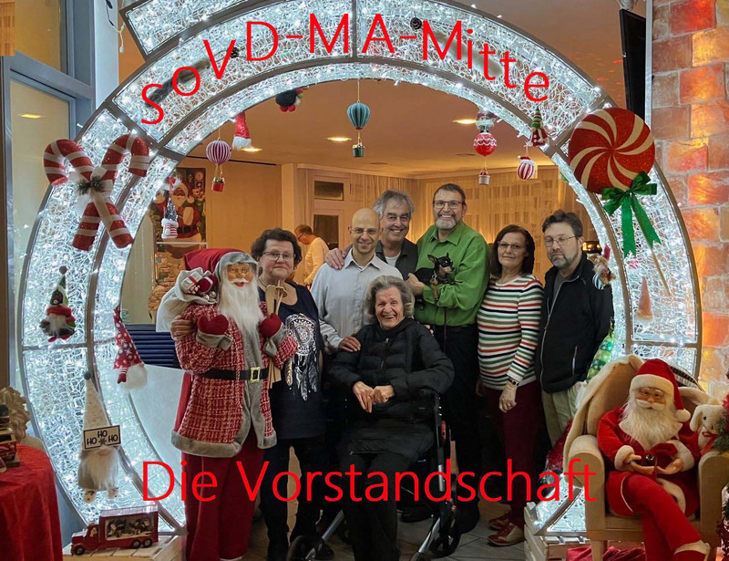 Gruppenbild mit sieben Personen mit weihnachtlicher Dekoration.