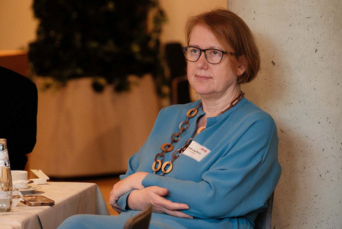 Eine Frau sitzt an einem Tisch an einer Säule. 