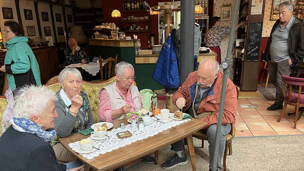 Leute sitzen am Tisch und essen.