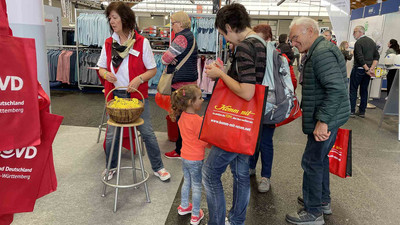 Heike Sommerauer-Dörzapf mit Besucher*innen am Stand.