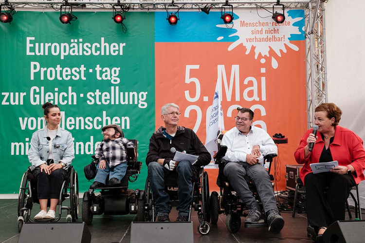 Fünf Menschen auf einer Bühne. 