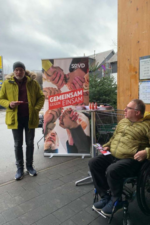 Zwei SoVD-Mitglieder am Infostand