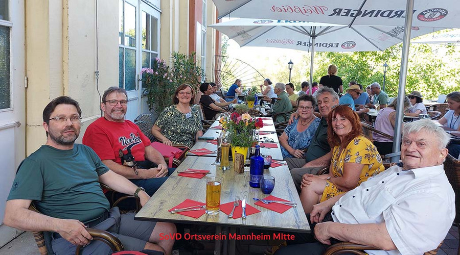 Menschengruppe sitzt in einem Biergarten am Tisch
