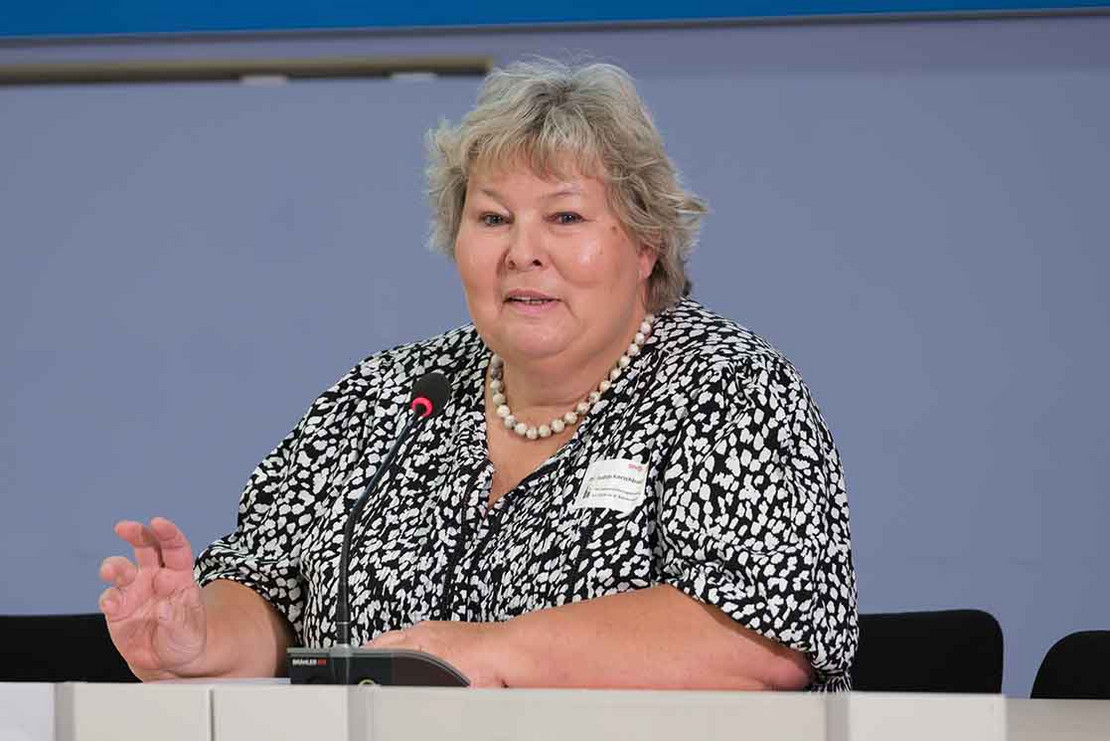 Frau redet auf dem Podium.