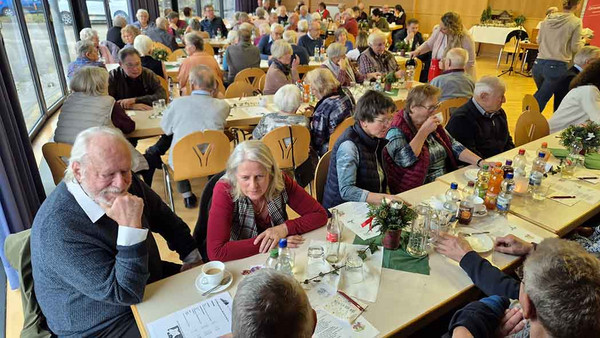 Menschen sitzen an gedeckten Tischen