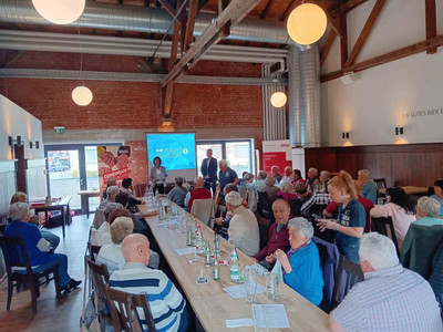 Vollbesetzter Saal mit Vortragendem