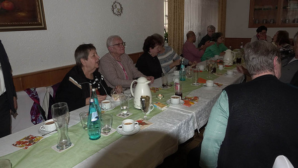 Menschen sitzen an einem langen Tisch