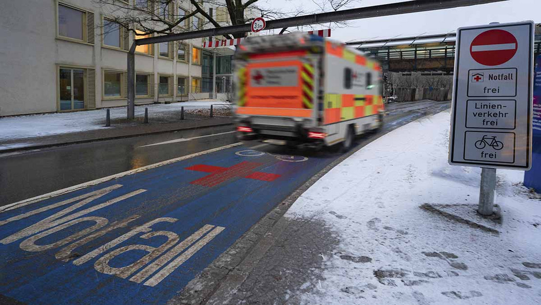 Ein Rettungswagen fährt auf ein Klinkgelände. 