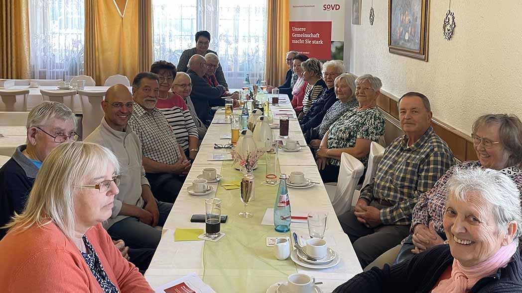 Gruppe sitzt an einem langen Tisch